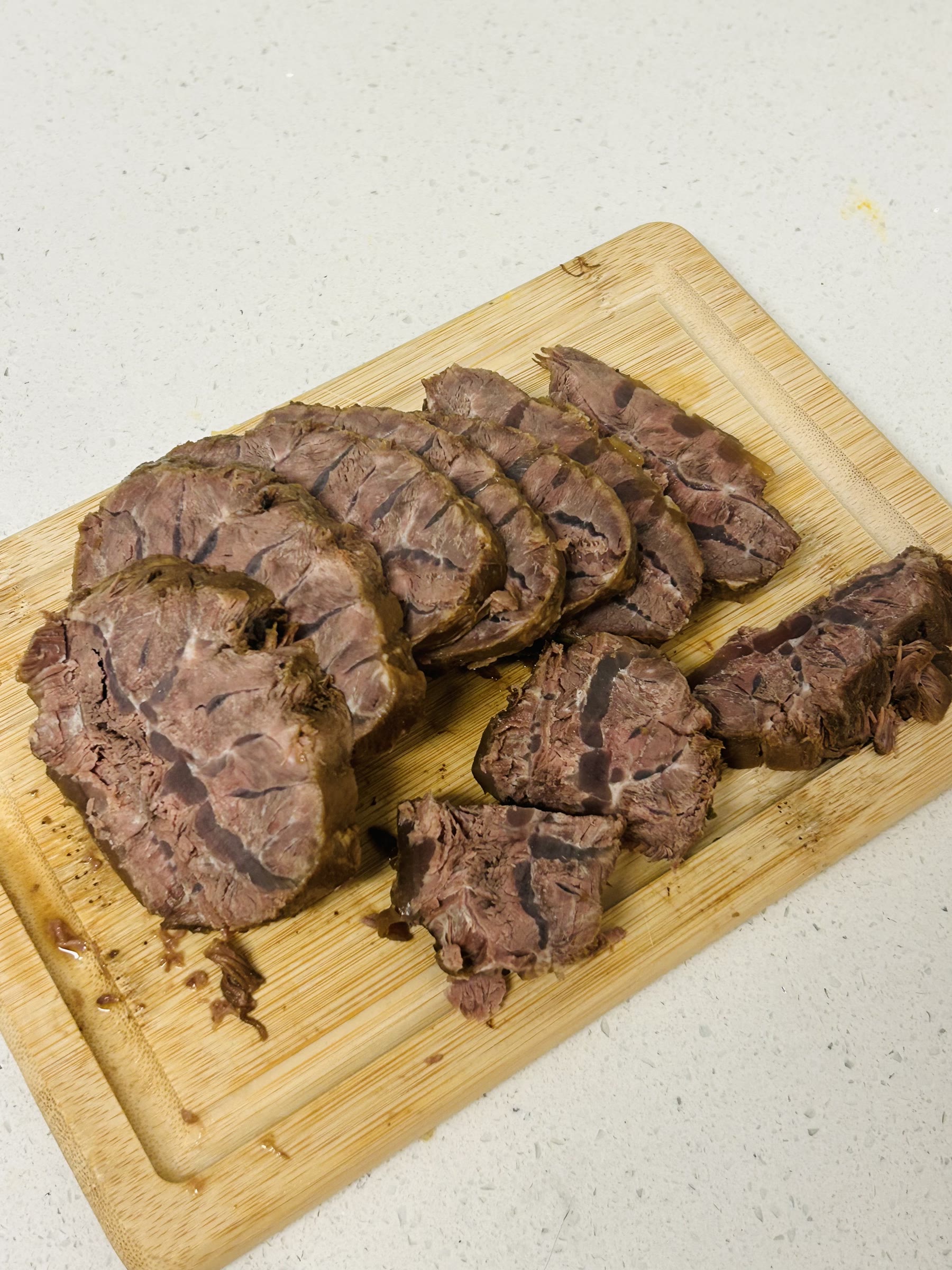 Sliced braised beef on a cutting board