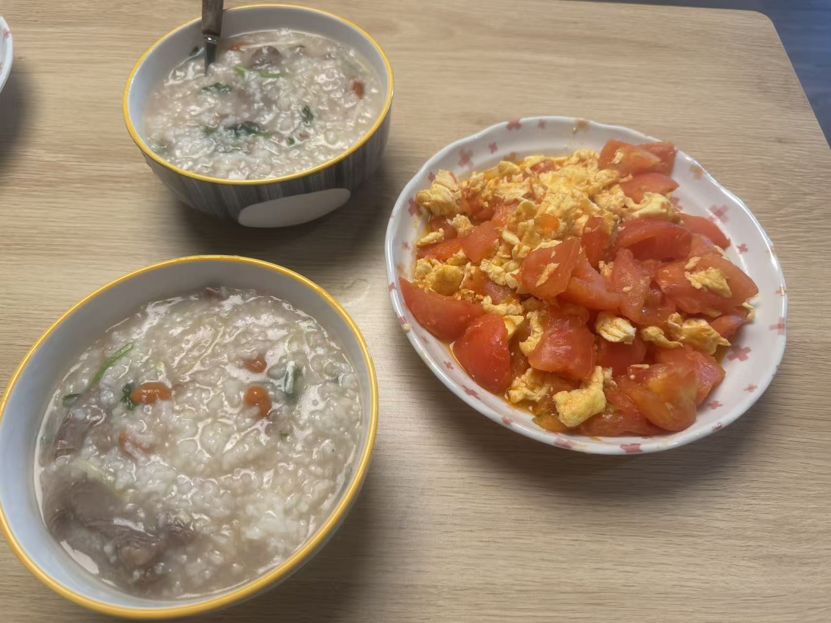 Congee and tomato eggs on a dining table