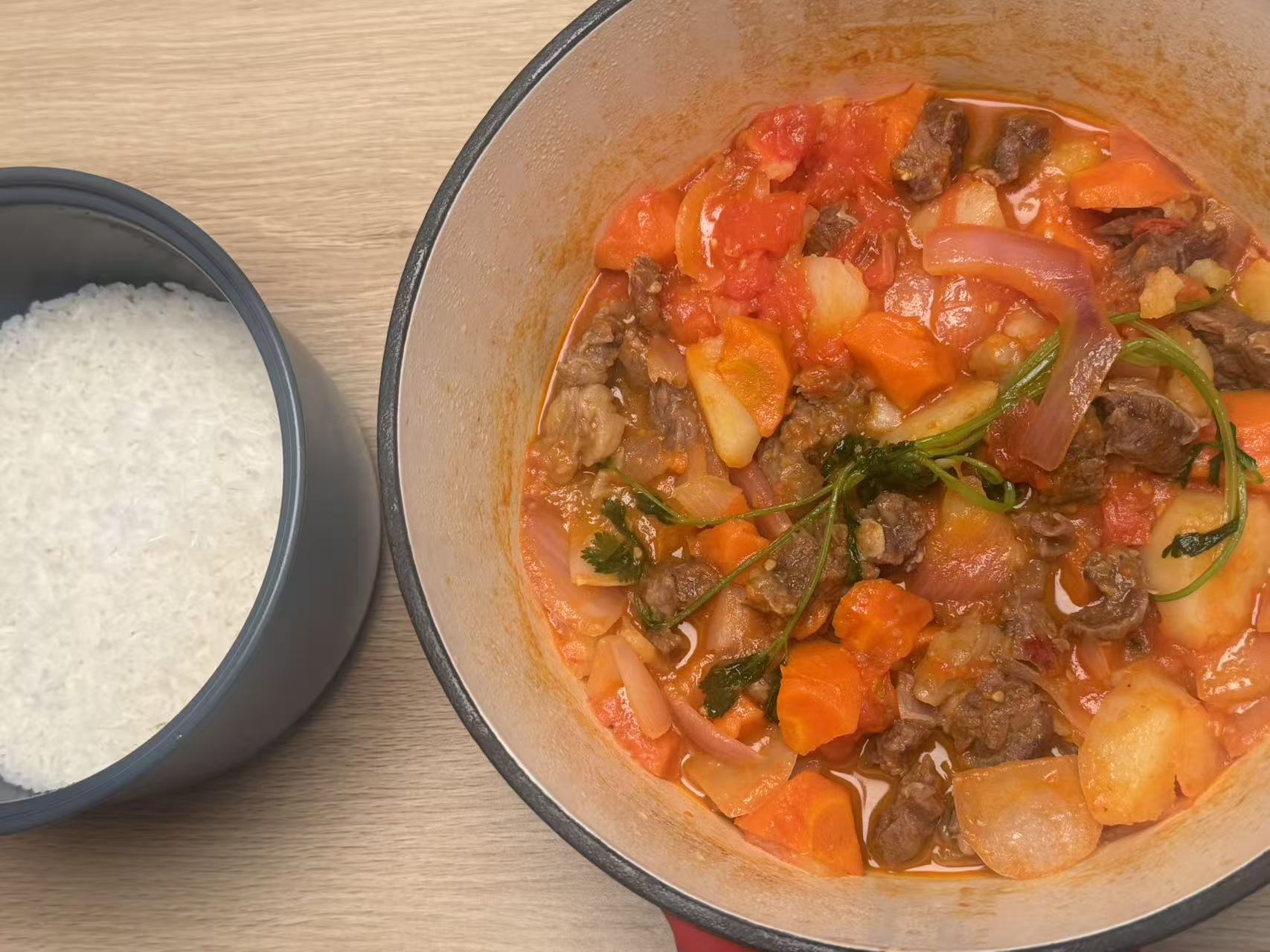 Tomato stew served with rice and vegetables